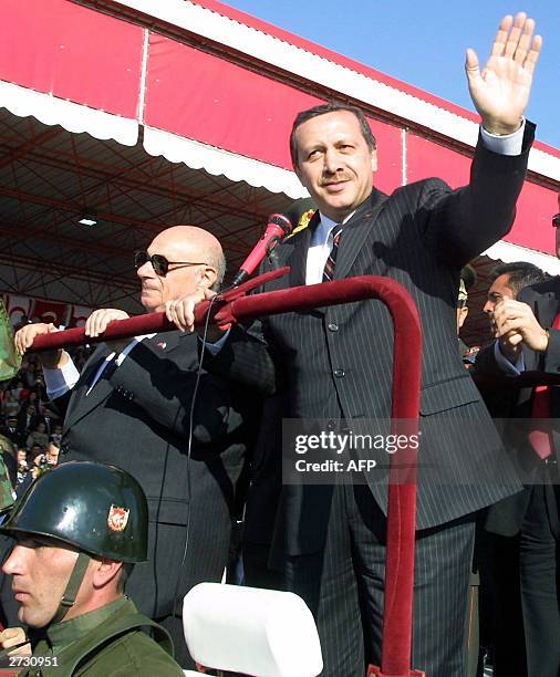 Turkish Prime Minister Recep Tayyip Erdogan waves while parading with Turkish Cypriot leader Rauf Denktash during ceremonies marking the 20th...