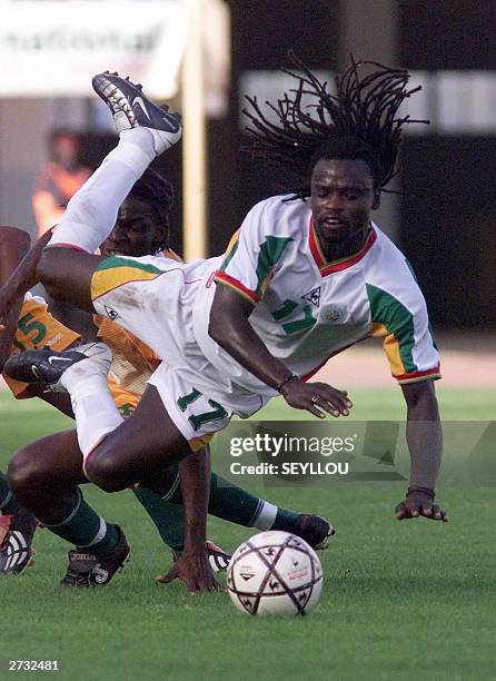 Senegal's Ferdinand Coly falls over the ball during a friendly soccer match against The Ivory Coast in Dakar, 15 November 2003 AFP PHOTO/SEYLLOU