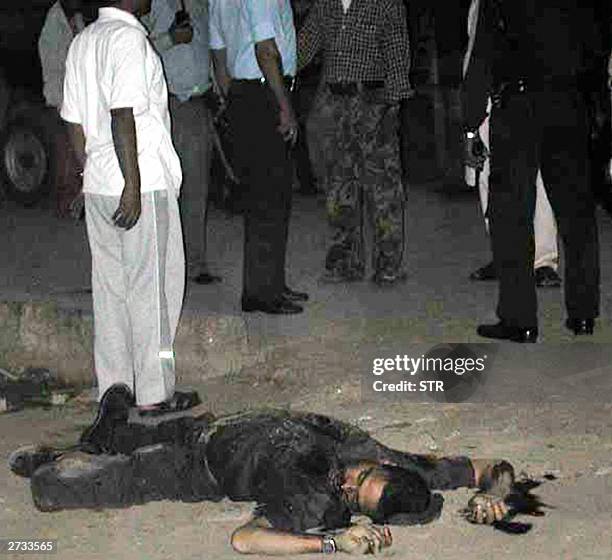 In this picture taken, 15 November 2003, the body of a Nepalese police officer lies on the ground as other security personel stand by following an...