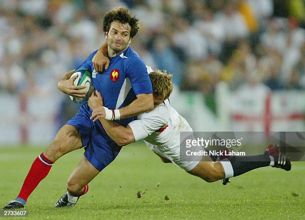 Christophe Dominici of France is tackled by Jonny Wilkinson during the Rugby World Cup Semi-Final match between England and France at Telstra Stadium...