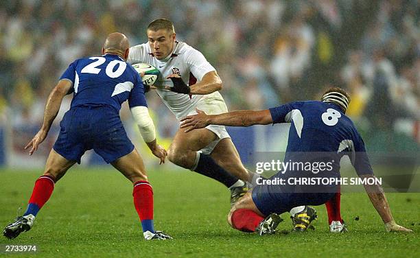 English winger Ben Cohen tries to pass a tackle French N8 Imanol Harinordoquy and fly-half Gerald Merceron during the Rugby World Cup semi final...