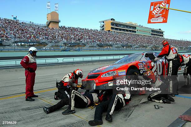 Crew members go to work repairing the Joe Gibbs Racing Home Depot Chevrolet of driver Tony Stewart during the NASCAR Winston Cup Ford 400, on...