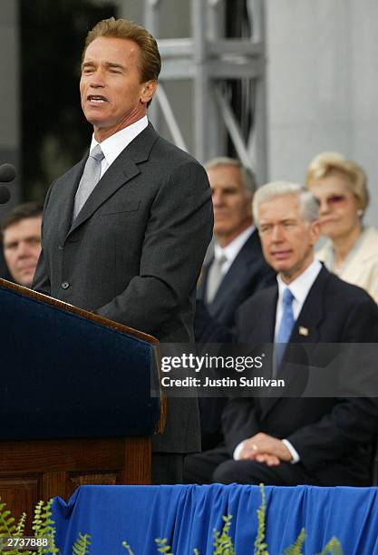 California Gov. Arnold Schwarzenegger speaks as former Gov. Gray Davis looks on during a swearing-in ceremony November 17, 2003 in Sacramento,...