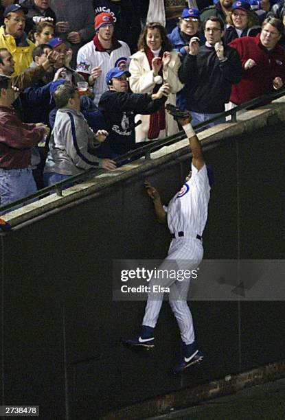 Fans interfere with outfielder Moises Alou of the Chicago Cubs on a ball hit by Luis Castillo of the Florida Marlins in the eighth inning during Game...