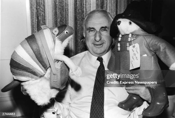 British children's book author Michael Bond stands with stuffed animal toys of his characters Paddington Bear and J.D. Polson the Armadillo, June 27,...