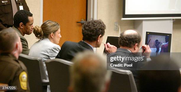 Convicted sniper John Allen Muhammad watches a video along with his defense team, Peter Greenspun Jonathan Shapiro, and Christie Leary during the...