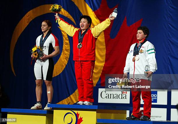 Shichun Shang of China on the podium as she accepts the Gold Medal for the combined Snatch, and Clean and Jerk with Nahla Ramadan of Egypt silver...