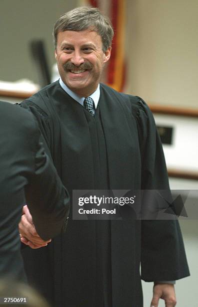 Prince William County Circuit Court Judge LeRoy Millette Jr. Shakes the hand of prosecutors after giving final instructions to the jury in the case...