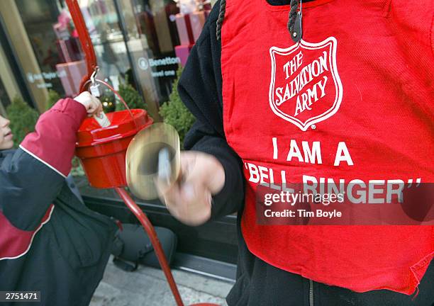 Donation is made as Salvation Army bell ringer Ruben Rios works outside a store November 21, 2003 on the Magnificent Mile in Chicago. Funds raised...