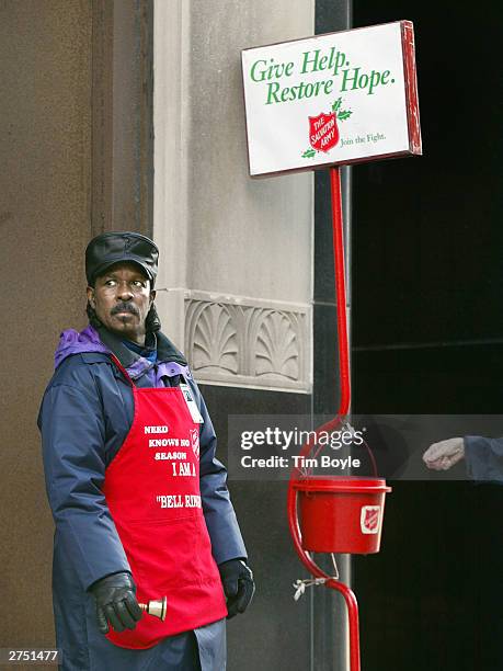 Donation is about to be dropped into the kettle of Salvation Army bell ringer Robert Walker outside a store on the Magnificent Mile November 21, 2003...