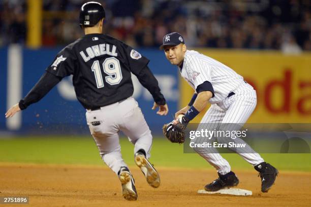 Shortstop Derek Jeter of the New York Yankees looks to turn a double play as Mike Lowell of the Florida Marlins slides into second base during game...