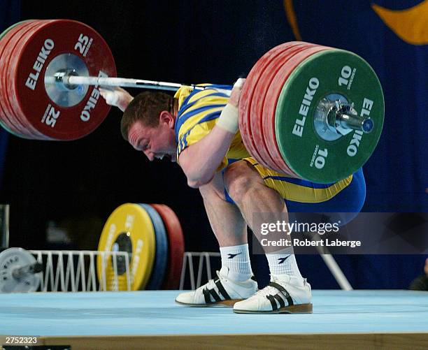 Denis Gotfrid of Ukraine twists his left elbow as he attempts to lift 195 Kilograms at the Snatch during the Men's 105 KG Group A competition at the...