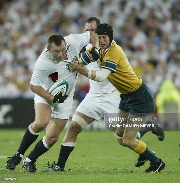 Wallaby fly-half Stephen Larkham tackles English hooker Steve Thompson during the Rugby World Cup final between Australia and England, 22 November...