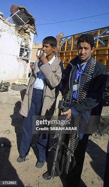 Two Iraqi police officers stand in front of the Khan Bani Saad police station hit early 22 November 2003 by a suicide bomb in this small town 20km...