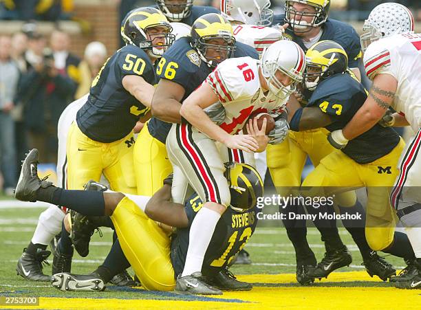 Quarterback Craig Krenzel of the Ohio State Buckeyes gets stopped as he attempts to run the ball through Jeremy Van Van Alstyne, Larry Harrison, Carl...