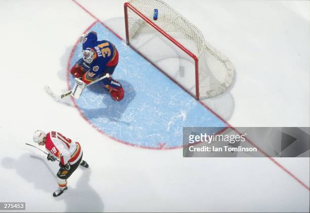 Overhead view of goaltender Grant Fuhr of the St. Louis Blues in action against center Marty McInnis of the Calgary Flames during a game at the...