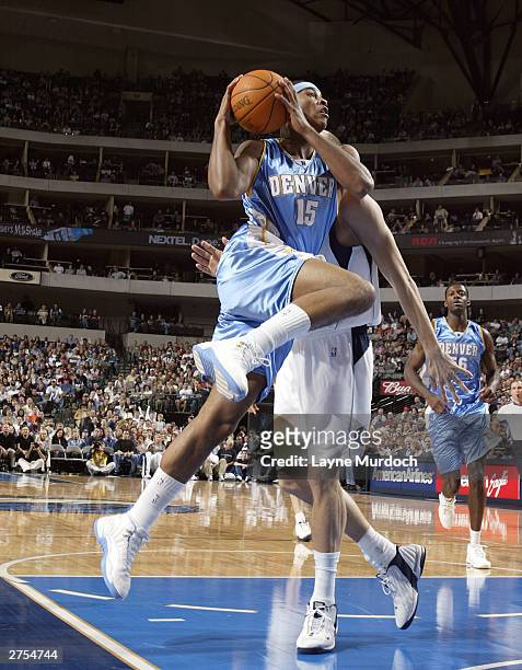 Carmelo Anthony of the Denver Nuggets takes a shot against Dirk Nowitzki of the Dallas Mavericks on November 22, 2003 at the American Airlines Center...