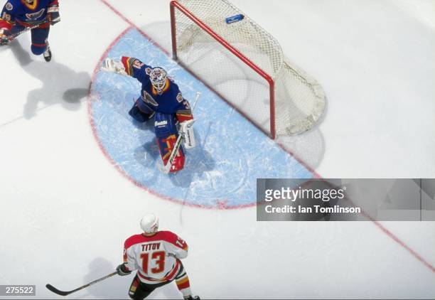 Goaltender Grant Fuhr of the St. Louis Blues in action against center German Titov of the Calgary Flames during a game at the Saddledome in Calgary,...