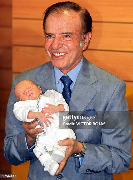 Carlos Menem, a controversial figure as Argentina's president from 1989-1999, holds Maximo Saul, his son with Chilean-born wife, former beauty queen,...