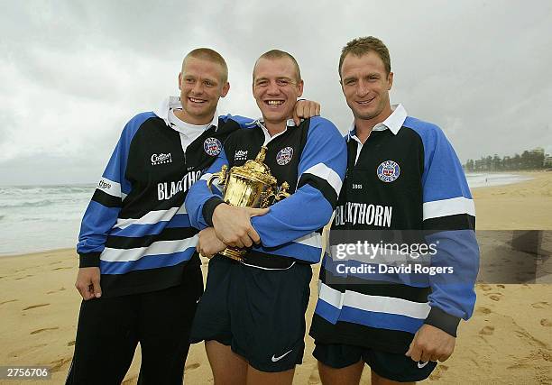 Iain Balshaw, Mike Tindall and Mike Catt of Bath hold the William Webb Ellis Trophy wearing their Zurich Premiership shirts pose on November 24, 2003...