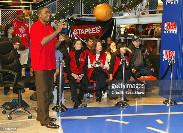 Isiah Thomas passes the ball to a contestant during a promotion on November 24, 2003 at the NBA store in New York City. Thomas is promoting the...