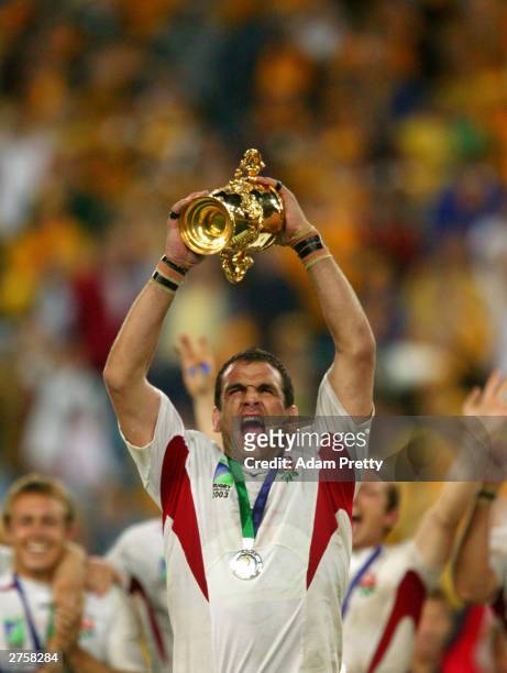 Martin Johnson the captain of England celebrates with the Webb Ellis trophy after England's victory in the Rugby World Cup Final match between...