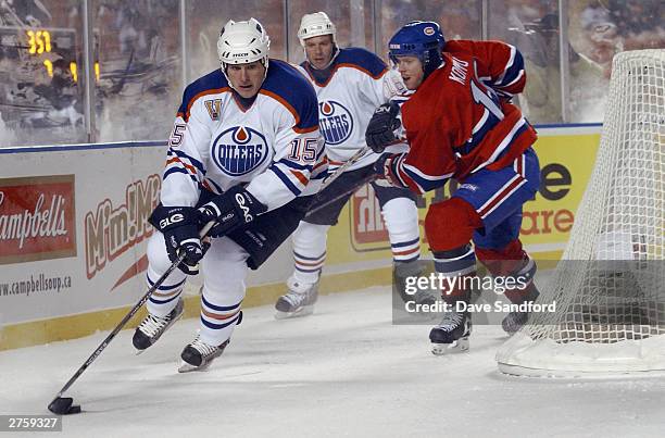 Brad Isbister of the Edmonton Oilers tries to avoid Saku Koivu of the Montreal Canadiens during the Molson Canadien Heritage Classic on November 22,...