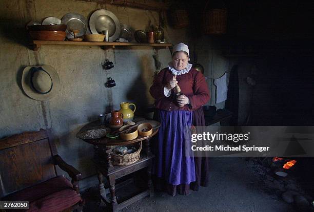 Asia Poppers, who portrays colonist Tryphosa Tracy, prepares fritters in her one-room house November 25, 2003 at Plimoth Plantation in Plymouth,...