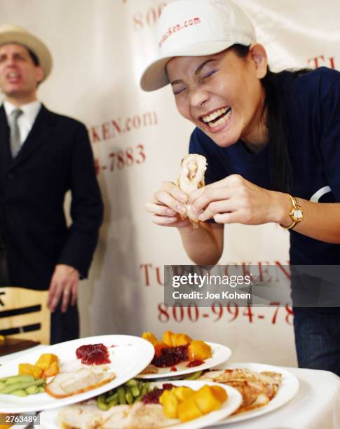 Sonya Thomas, 36-years-old and 100 pounds, stuffs her mouth during a Thanksgiving eating competition November 26, 2003 at Mickey Mantle's Restaurant...