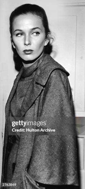 American actor and writer Brooke Hayward stands wearing a tweed cape, circa 1960.