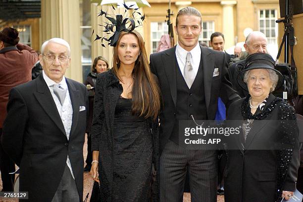 England football captain David Beckham stands with his wife, Victoria, and his maternal grandparents, Joseph and Peggy West, as he shows off the OBE...