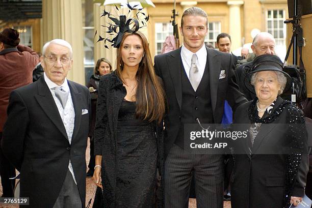 England football captain David Beckham stands with his wife, Victoria, and his maternal grandparents, Joseph and Peggy West, as he shows off the OBE...