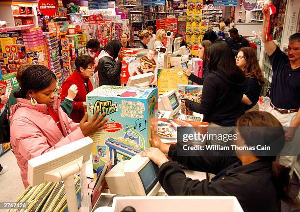 Customers pay for their items while doing their Black Friday shopping at KB Toys, which opened at 5am, in the King of Prussia Mall November 28, 2003...