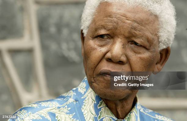 Nelson Mandela listens at a press conference for "46664 - Give One Minute of Your Life to AIDS" on Robben Island where he was impisoned for 18 years...