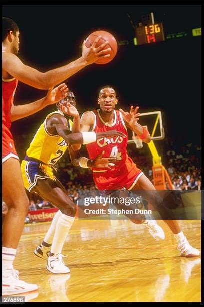 Center Brad Daugherty of the Cleveland Cavaliers makes a pass to team player guard Ron Harper over the defense of the Los Angeles Lakers during a...