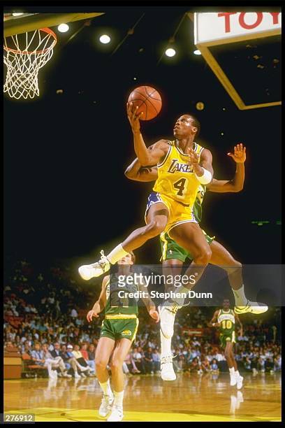 Guard Byron Scott of the Los Angeles Lakers leaps for the hoop over the Seattle SuperSonics during a game at The Forum, in Inglewood, California....