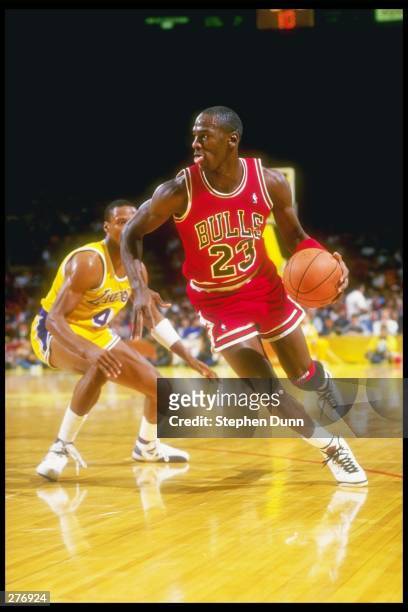 Guard Michael Jordan of the Chicago Bulls swiftly moves away from guard Byron Scott of the Los Angeles Lakers during a game held at The Forum in...