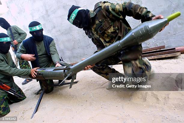 Masked Palestinian gunmen from the militant group Hamas prepare to fire a homemade rocket at Israeli forces in the area where an Israeli Army...