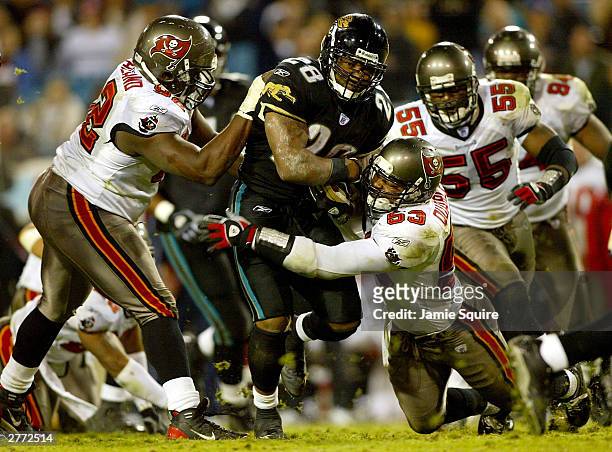 Fred Taylor of the Jacksonville Jaguars carries the ball as Shelton Quarles, Anthony McFarland, and Derrick Brooks of the Tampa Bay Buccanneers...