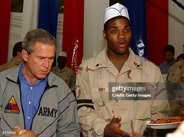 Seen in this handout photo provided by the U.S. Army, President George W. Bush delivers food during a surprise visit on Thanksgiving Day, November...