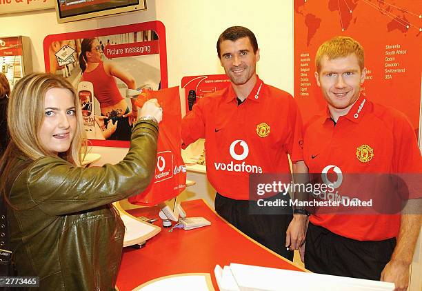 Roy Keane and Paul Scholes help a Vodafone customer as Manchester United announced a new sponsorship deal with Vodafone at Claridge's Hotel on...