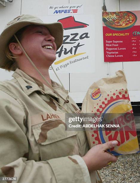 Soldier holds a Burger King package at the military base of Talil, near Nasiriyah in southern Iraq, 01 December 2003. Pizza Hut and Burger King are...