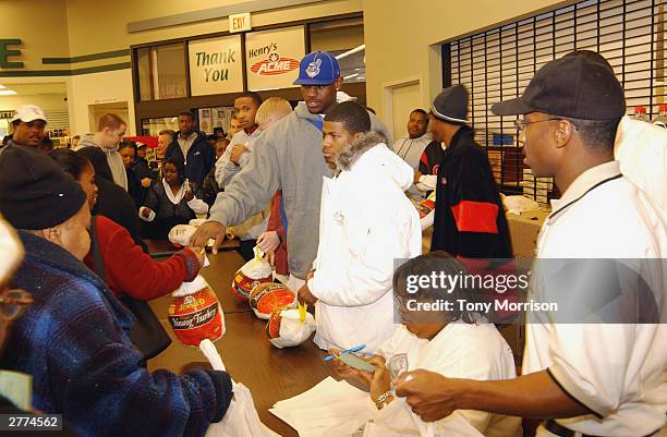 LeBron James of the Cleveland Cavaliers hands out turkeys during the LeBron James Holiday Turkey Giveaway at Acme Supermarket on November 24, 2003 in...