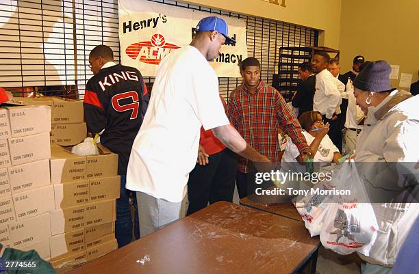 LeBron James of the Cleveland Cavaliers hands out turkeys during the LeBron James Holiday Turkey Giveaway at Acme Supermarket on November 24, 2003 in...