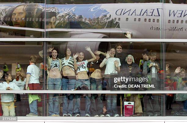 Group of female fans lift their tops to reveal a written message to Lord of The Rings star Orlando Bloom while boarding their Air New Zealand 767...