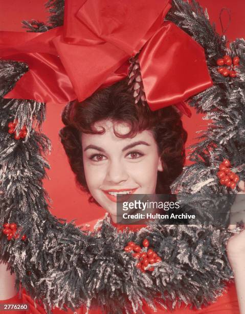 Headshot portrait of American actor and singer Annette Funicello, posing with her head encircled by a decorative Christmas wreath, circa 1955. There...