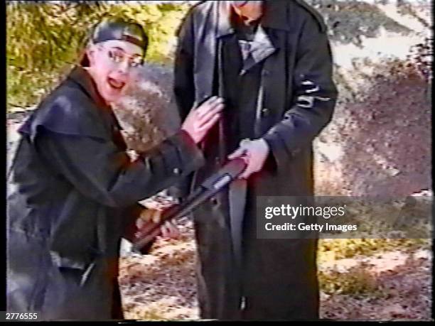 Eric Harris points out a sawed-off shotgun held by friend Dylan Klebold at a makeshift shooting range March 6, 1999 in Douglas County, CO in this...