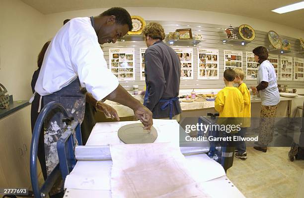 Assistant coach T.R. Dunn of the Denver Nuggets takes a pottery class with students from The Havern Center on November 20, 2003 at Mile Hi Ceramics...
