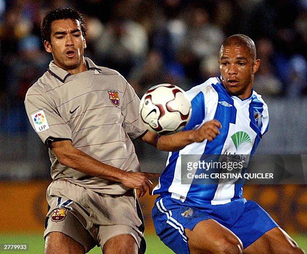 Malaga's Portuguese Edgar fights for the ball with Barcelona's Van Bronckhorst during their Spanish league match at La Rosaleda stadium in Malaga 03...