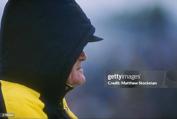 Head coach Hayden Fry of the Iowa Hawkeyes stands on the sideline with a hood over his head as he looks on during a play in the Hawkeyes 31-21...